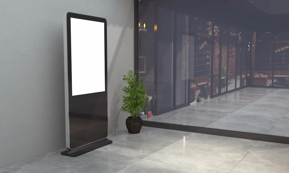 Intérieur commercial moderne avec écran publicitaire numérique sur pied à affichage blanc vierge